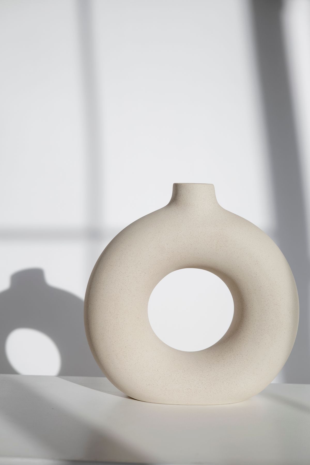 Photograph of a circular cream ceramic vase